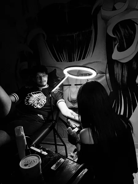 Bya trabalhando numa tatuagem no estúdio