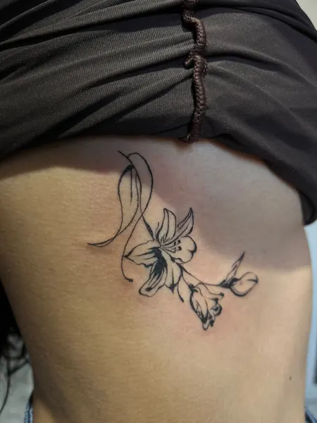 Outra vista da tatuagem floral na lateral do corpo