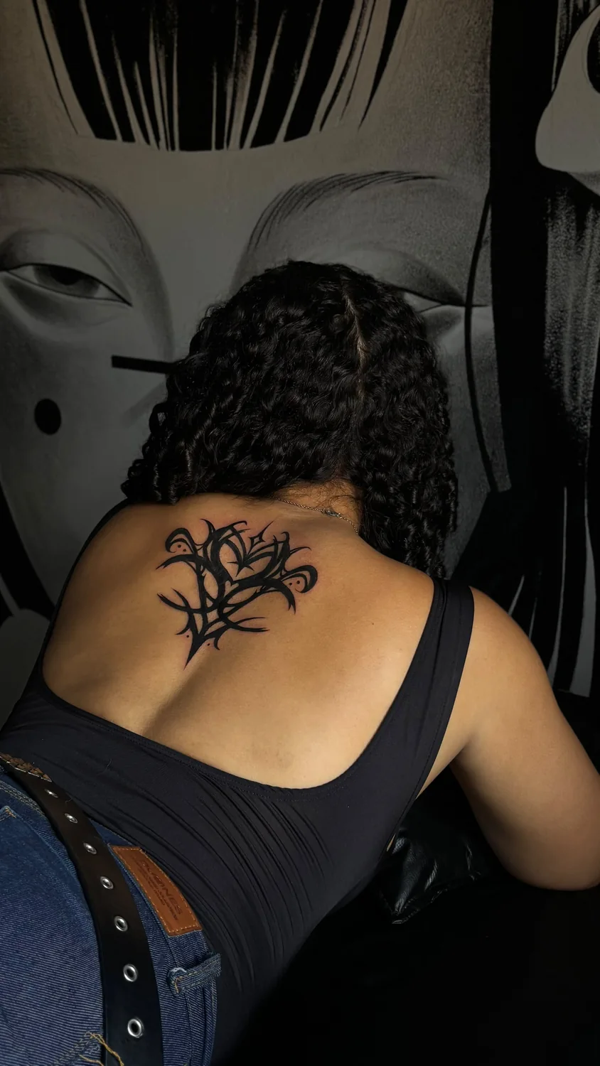 Tatuagem ornamental na parte superior das costas