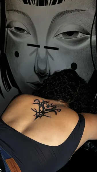Tatuagem ornamental nas costas junto ao mural