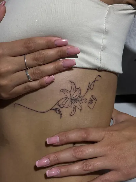 Tatuagem floral pequena na lateral do corpo