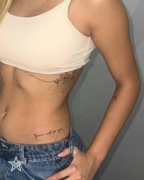 Tatuagens florais e uma frase na lateral do corpo
